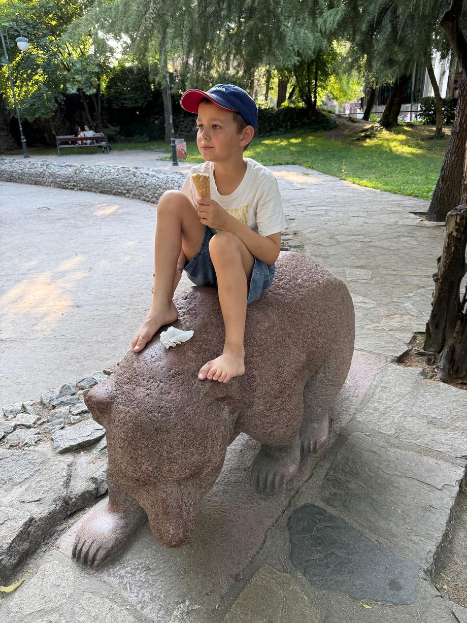 Anton sitting on central park bear statue