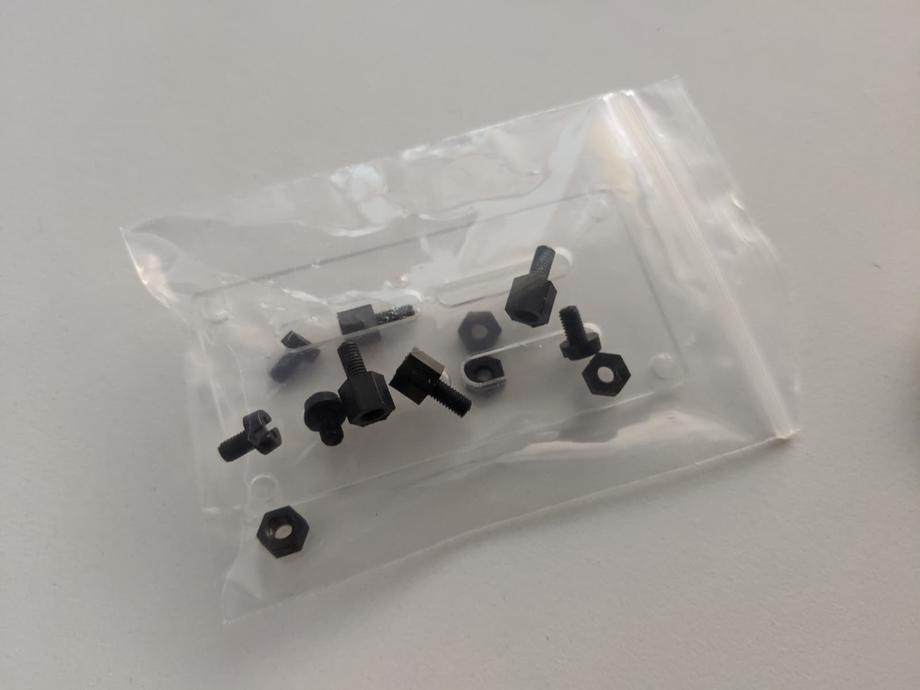 screws and acrylic stand in a plastic bag